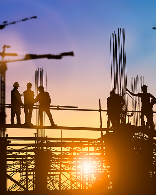 Construction workers on sunrise background